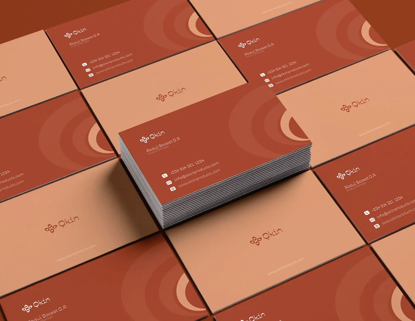Business cards fanned across a surface in two terracotta tones